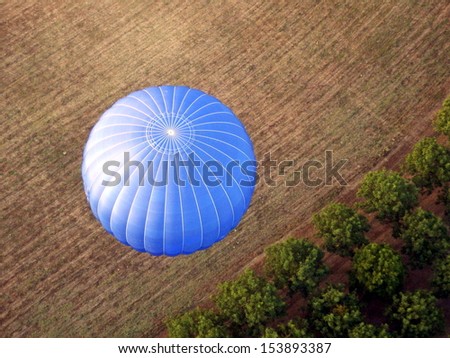 Hot air balloon taking off from a field. Photo taken from another balloon
