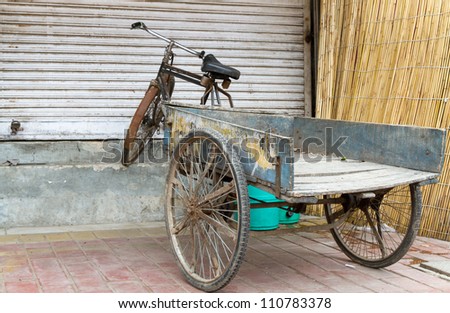 Old bicycle with trailer in Delhi, India, in front of a closed shop