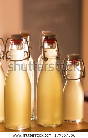 Bottles filled with elderflower syrup against the light