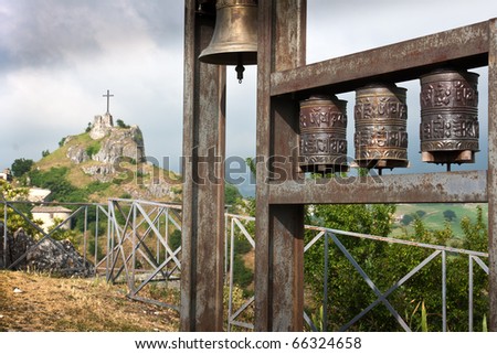 Prayer wheels and christian cross on a hill in Italy