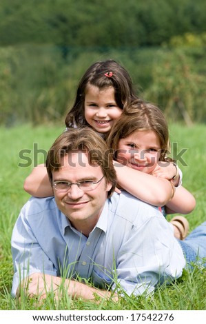 Young father with his two daughters in a farmer´s field