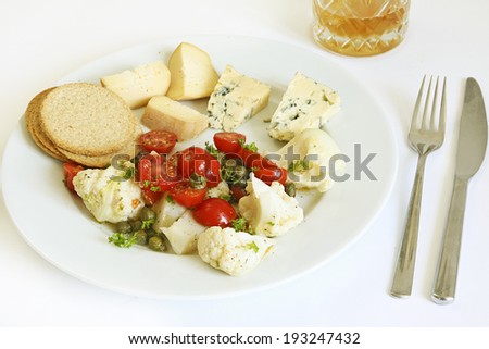 Cheese with a cauliflower, tomato and caper side salad, cheese biscuits and a non-alcoholic ginger beer