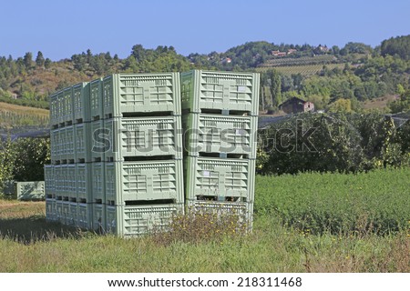 Apple boxes stacked in a field waiting to be fill when the crop is picked, Tallard aerodrome, Haut-Alpes, France