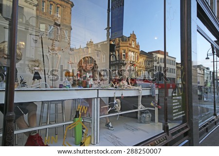 LEEDS, UK - JUNE 6, 2015: Reflections in shop window. The Leeds City Region is the UK\'s largest economy and population centre outside London, generating 4% of national economic output