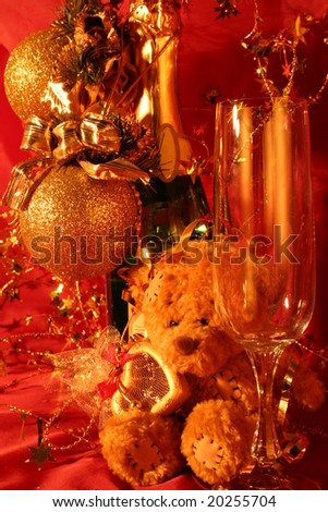 Holiday card: Close-up of glasses, champagne bottle and bear toy