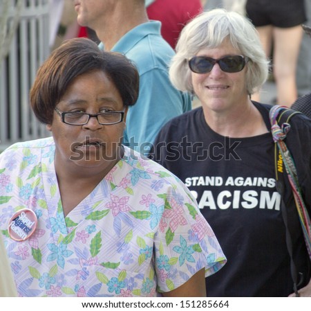 ASHEVILLE, NORTH CAROLINA, USA - AUGUST 5: A black and white woman protest racism at a Moral Monday Rally on August 5, 2013 in Asheville