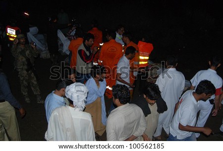 ISLAMABAD, PAKISTAN - APR 20: Rescue working work in dark and rain at the site of the plane crash near Pakistan's capital city of Islamabad that killed all 127 passengers April 20, 2012 in Islamabad.