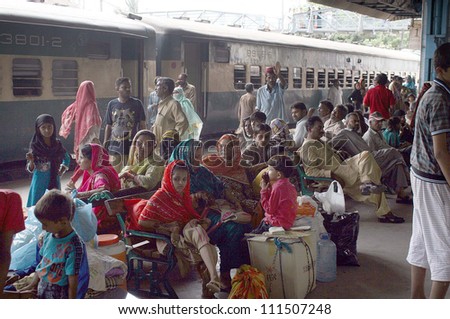 KARACHI, PAKISTAN - AUG 30: Passengers with their bags gather at platform as trains are late from their original schedules at Cantt railway station  on August 30, 2012 in Karachi, Pakistan.