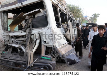 PESHAWAR, PAKISTAN - SEPT 19: People look wreckage of a vehicle that was destroyed in bomb explosion at Kohat Road on September 19, 2012 in Peshawar, Pakistan.