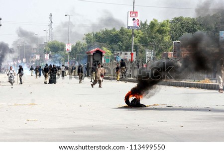 PESHAWAR, PAKISTAN - SEP 21: Smoke rise from tear gas shells fired by police officials during protest rally against blasphemy anti-Islamic movie released on September 21, 2012  in Peshawar.