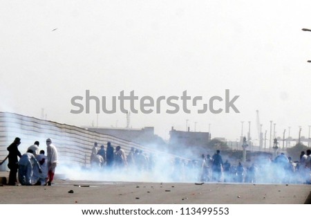 KARACHI, PAKISTAN - SEP 21: Smoke rise from tear gas shells fired by police officials during protest rally against blasphemy anti-Islamic movie released on September 21, 2012 in Karachi.