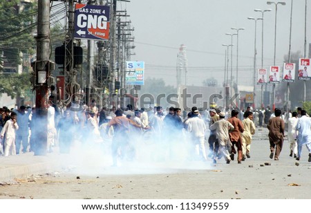 PESHAWAR, PAKISTAN - SEP 21: Smoke rise from tear gas shells fired by police officials during protest rally against blasphemy anti-Islamic movie released on September 21, 2012 in Peshawar.