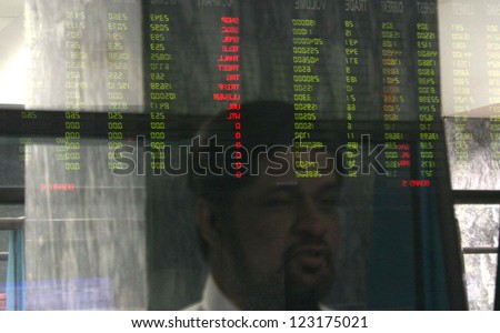 KARACHI, PAKISTAN - DEC 31: Stockbroker looks at the latest share prices on digital board during last trading session of the year 2012 at the Karachi Stock Exchangeon December 31, 2012 in Karachi.