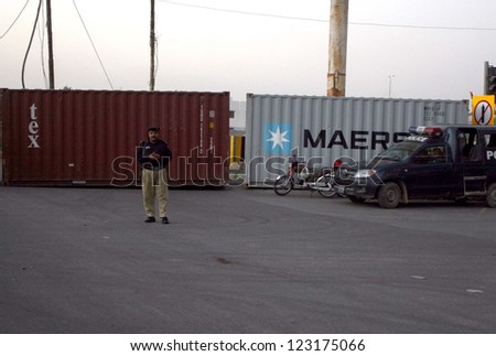 KARACHI, PAKISTAN - DEC 31: Security officials close the road with the help of containers leads towards Seaview Beach to control law and order situation on December 31, 2012 in Karach.