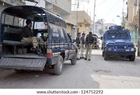 KARACHI, PAKISTAN - JAN 15: Police officials stand alert during targeted search operation against criminals at Chanesar Goth on January 15, 2013 in Karachi.