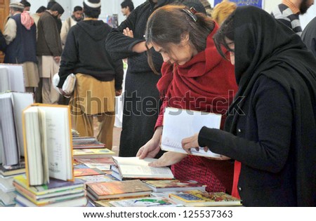 LAHORE, PAKISTAN - JAN 22: People take keen interest in books at a stall during Books  Exhibition held on January 22, 2013 in Lahore.