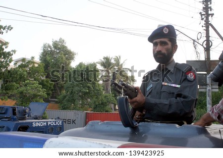 KARACHI, PAKISTAN - MAY 22: Police stand alert to avoid untoward incident while closed road that lead towards Governor House due to high-security alert in red zone area  on May 22, 2013 in Karachi.