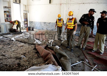 PESHAWAR, PAKISTAN - JUN 21: Rescue and police officials inspect the site after suicide bomb blast at Hussaini Madrassa Chamkini area  on June 21, 2013 in Peshawar. At least 14 people were killed
