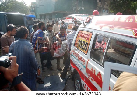 KARACHI, PAKISTAN - JUN 26: Rescue officials busy in rescue work at the site of a bomb blast targeting the convoy of Sindh High Court Justice Baqar Maqbool, at Burns Road on June 26, 2013 in Karachi.