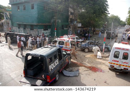 KARACHI, PAKISTAN - JUN 26: Security officials inspect the site of a bomb blast targeting the convoy of Sindh High Court Justice Baqar Maqbool, at Burns Road on June 26, 2013 in Karachi.