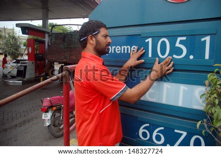 KARACHI, PAKISTAN - AUG 01: Fuel station employee displays new prices of petroleum products at a fuel station on August 01, 2013 in Karachi. The government increased the prices of petrol and diesel.