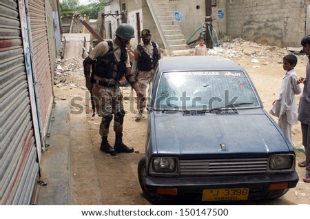 KARACHI, PAKISTAN - AUG 15: Police and rangers officials cordon-off the area during  targeted search operation against criminals near Safari Park in the Madu Goth area on August 15, 2013 in Karachi.