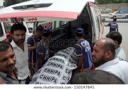 KARACHI, PAKISTAN - AUG 15: Rescue shift dead body of police official, who lost his life during targeted search operation against criminals in the Madu Goth area on August 15, 2013 in Karachi.