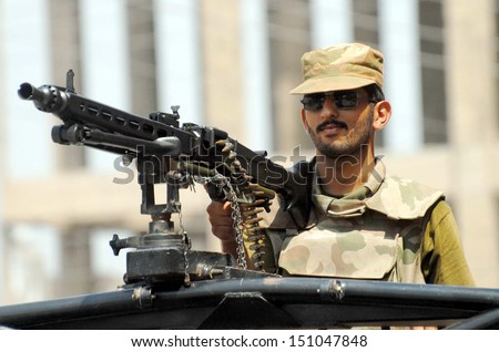 PESHAWAR, PAKISTAN - AUG 22: Security officials stand alert to avoid untoward incidents at a polling station during by-election for NA-01 on August 22, 2013 in Peshawar.