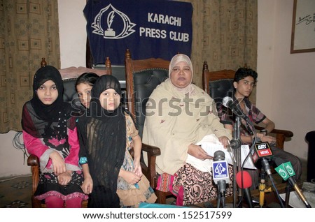 KARACHI, PAKISTAN - SEP 02: Samina Naz along with her unidentified children addresses to media persons against land mafia who grabbed her house, during a press conference on Sept. 02, 2013 in Karachi