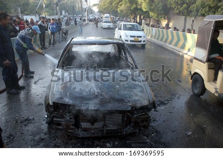 KARACHI, PAKISTAN - JAN 02: Fire fighters extinguishing fire that erupted on a car due to short circuit near Clifton Bridge on January 02, 2014 in Karachi.