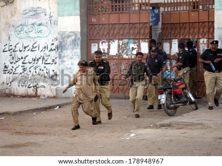 KARACHI, PAKISTAN - FEB 26: Police arresting teachers who were protesting against  corruption in Education Department of Sindh during a demonstration on February 26, 2014 in Karachi.