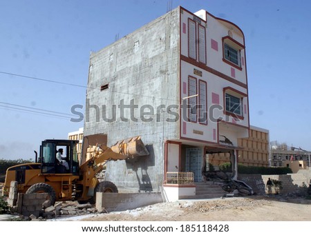 KARACHI, PAKISTAN - APR 02: Heavy machinery devastating illegal houses constructed on government property in Chakra Goth area of Korangi, on April 02, 2014 in Karachi.