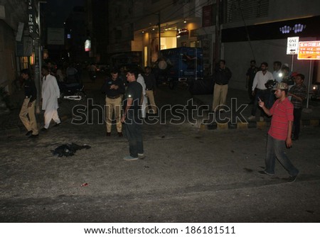 KARACHI, PAKISTAN - APR 08: Police officials are gathering at venue after suspected bomb blast near a famous garment store at Zamzama Street in DHA, on April 08, 2014 in Karachi.