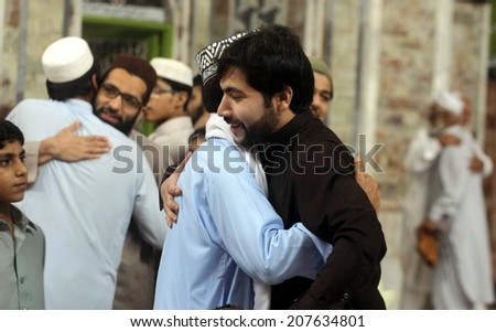 PESHAWAR, PAKISTAN - JUL 28: Faithful Muslims hug with each other after Eid-ul-Fitar  prayer at Masjid-e-Mohabbat Khan on July 28, 2014 in Peshawar.