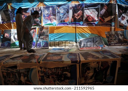 PESHAWAR, PAKISTAN - AUG 18: People taking keen interest in posters of  desolated people of Gaza by invasion of Israel, during a photo exhibition on August 18, 2014 in Peshawar.
