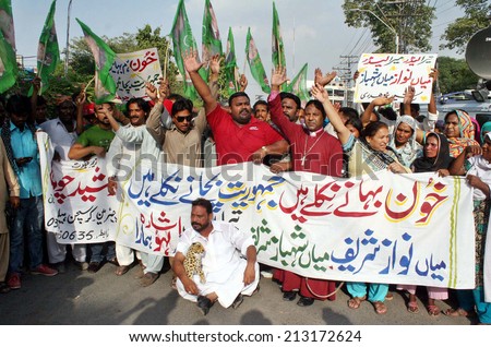 LAHORE, PAKISTAN - AUG 26: Supporters of Muslim League-N chant slogans in favor of Prime Minister during protest demonstration arranged by Christian Help Line Pakistan, on August 26, 2014 in Lahore.