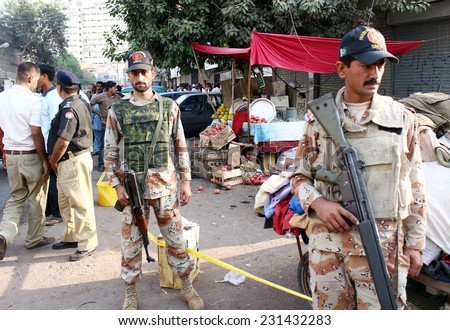 KARACHI, PAKISTAN - NOV 18: Security official and perturbed people gather at the site after a hand grenade attack by unknown assailants near Kharadar Police Station on November 18, 2014 in Karachi.
