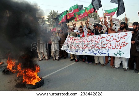 MULTAN, PAKISTAN - DEC 09: Activists of Tehreek-e-Insaf (PTI) burn tyres as they are  protesting against the killing of two workers and injuring scores of PTI workers on  December 09, 2014 in Multan.