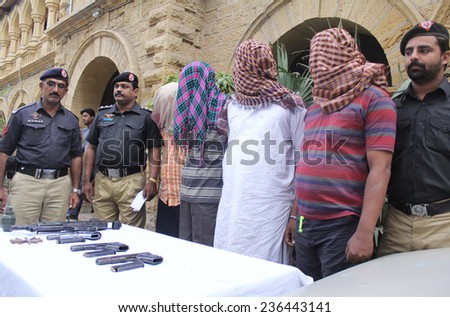 KARACHI, PAKISTAN - DEC 09: Special Investigation Unit of Police (SIU) staffs  showing weapons recovered from criminals who were alleged in multiples banks robberies, on December 09, 2014 in Karachi.
