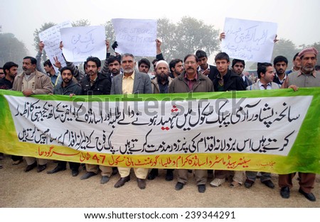 PESHAWAR, PAKISTAN - DEC 22: Teachers and students of Govt school  chant slogans against killing of innocent school children and staff members of Army Public School on December 22, 2014 in Peshawar.