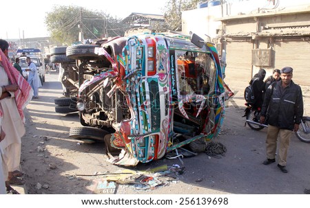 KARACHI, PAKISTAN - FEB 26:Pol ice officials People gather near overturned damaged  passenger bus after traffic accident due to over speeding, at Shershah road on February 26, 2015 in Karachi.
