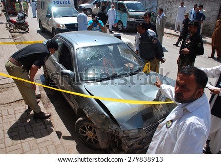 PESHAWAR, PAKISTAN - MAY 20: Security staffs inspecting damage car of Deputy 
Superintendent Bahadur Khan, at Shakeebad area on May 20, 2015 in Peshawar. open fire on car when Bahadur Khan on drive.
