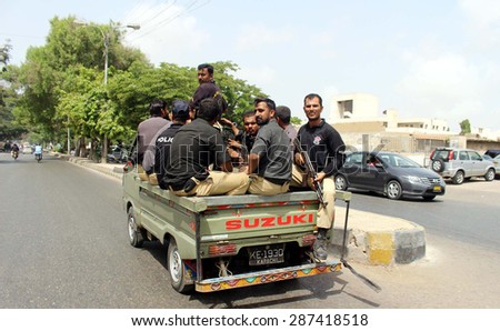 KARACHI, PAKISTAN - JUN 15: Police officials carry weapons traveling on private vehicle violating traffic rules pass through red-zone area near Supreme Court. on June 15, 2015 in Karachi.