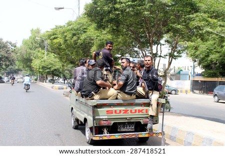 KARACHI, PAKISTAN - JUN 15: Police officials carry weapons traveling on private vehicle violating traffic rules pass through red-zone area near Supreme Court. on June 15, 2015 in Karachi.