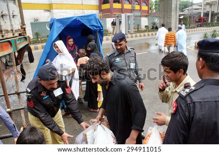 LAHORE, PAKISTAN - JUL 09: Police checking people, who are entering in \
procession as security has been tightened during mourning procession connection of Youm-e-Ali (A.S) on July 09, 2015 in Lahore.
