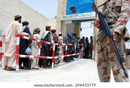 CHAMAN, PAKISTAN - JUL 14: Pakistani security guard is stands alert when the Afghan \
prisoners are stand in the line handing over to Afghan authority at Friendship Gate on July 14, 2015 in Chaman.