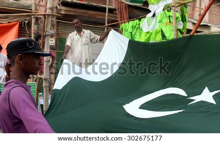 KARACHI, PAKISTAN - AUG 03: People busy in buying buntings, flags and badges on the occasion of Pakistan Independence Day coming ahead on August 14, at Pakistan Chowk on August 03, 2015 in Karachi.