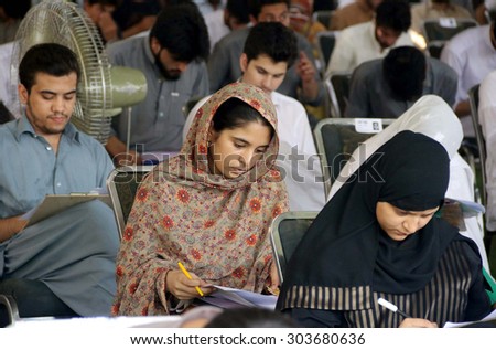 PESHAWAR, PAKISTAN - AUG 06: Students are busy in solving their question paper during aptitude test of University of Engineering and Technology, on August 06, 2015 in Peshawar.