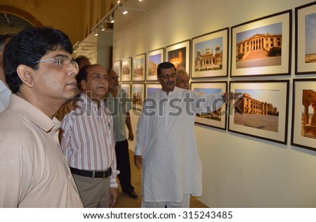 KARACHI, PAKISTAN - SEP 10: Karachi Metropolitan Corporation officers are taking keen \
interest in images by Rehan Khan during a photographic exhibition on September 10, 2015  in Karachi.