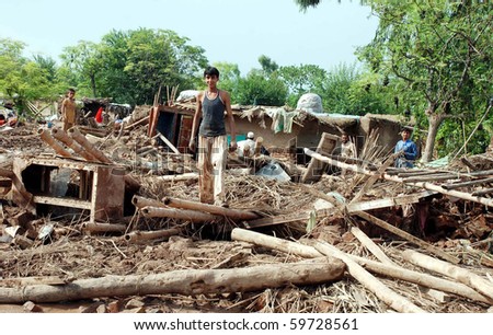 PESHAWAR, PAKISTAN - JUL 31: People remove household items from their collapsed house after flood water has passed the Pabbi area on July 31, 2010 in Peshawar, Pakistan.